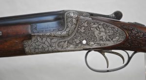 MERKEL 203E LUXUS - 20 GAUGE - DOUBLE TRIGGERS - DEEP GAME SCENE ENGRAVED WITH OAK LEAF CARVED STOCK - OAK AND LEATHER CASE